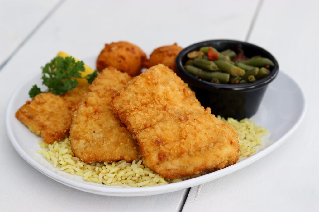 a seafood lent meal with fried fish filets, rice and vegetables