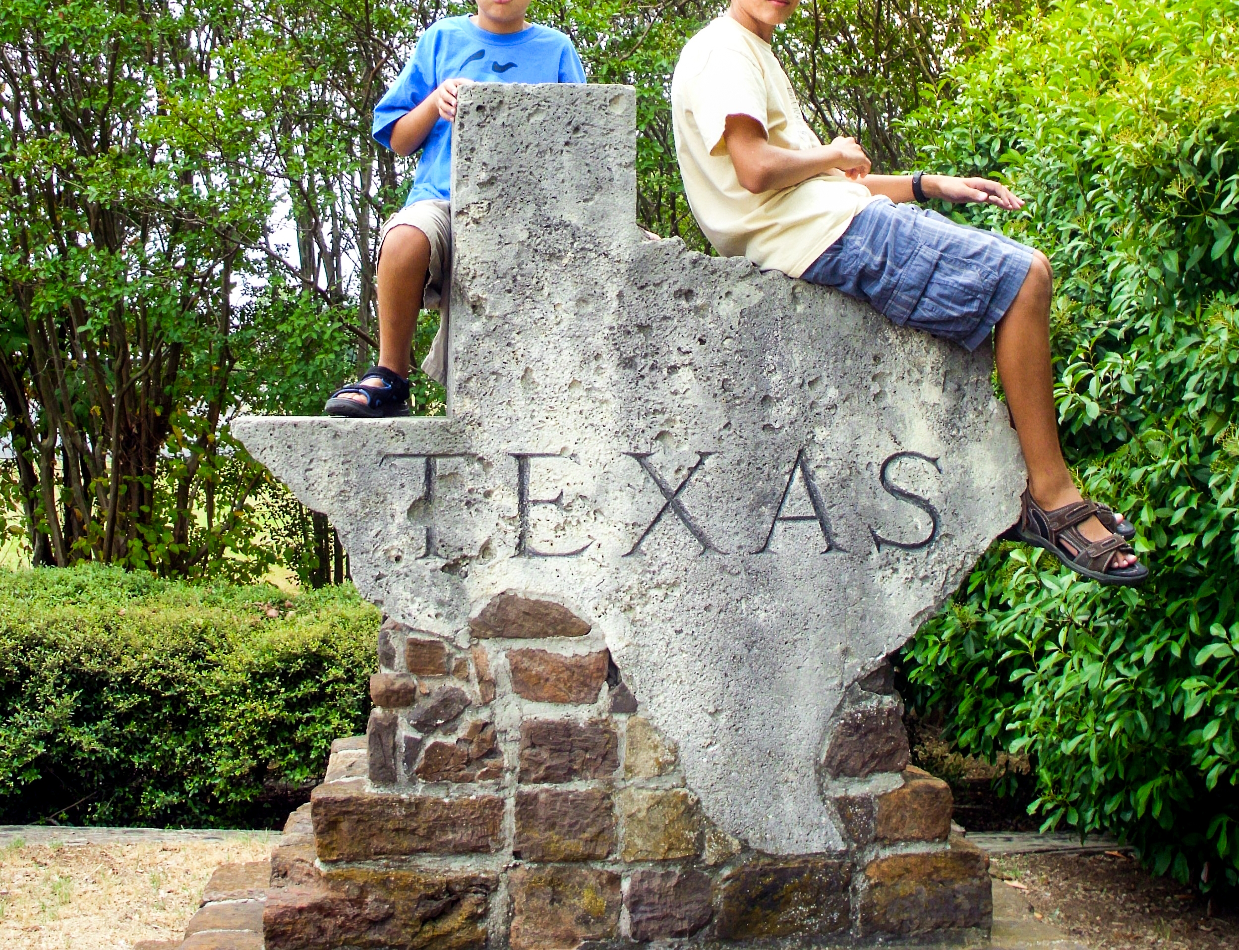 Boys sitting on a Texas map structure